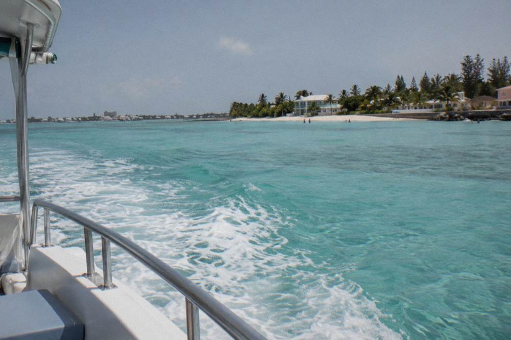 Turquoise water over pale sand seen from the deck of a small boat