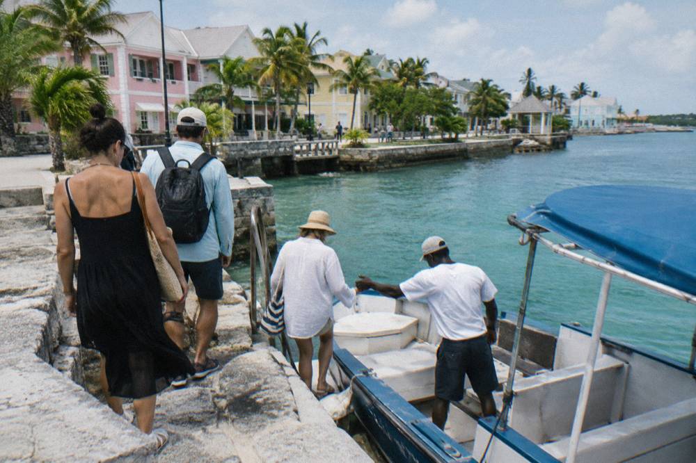 Passengers boarding a small tour boat at a Nassau waterfront dock