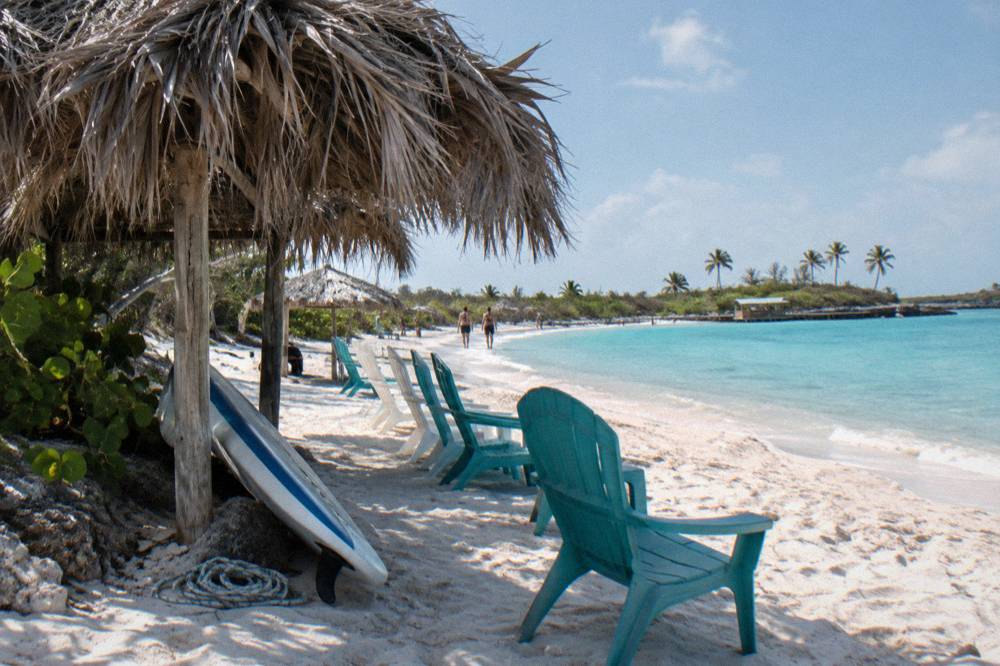 Beach chairs and shaded seating on a white sand beach