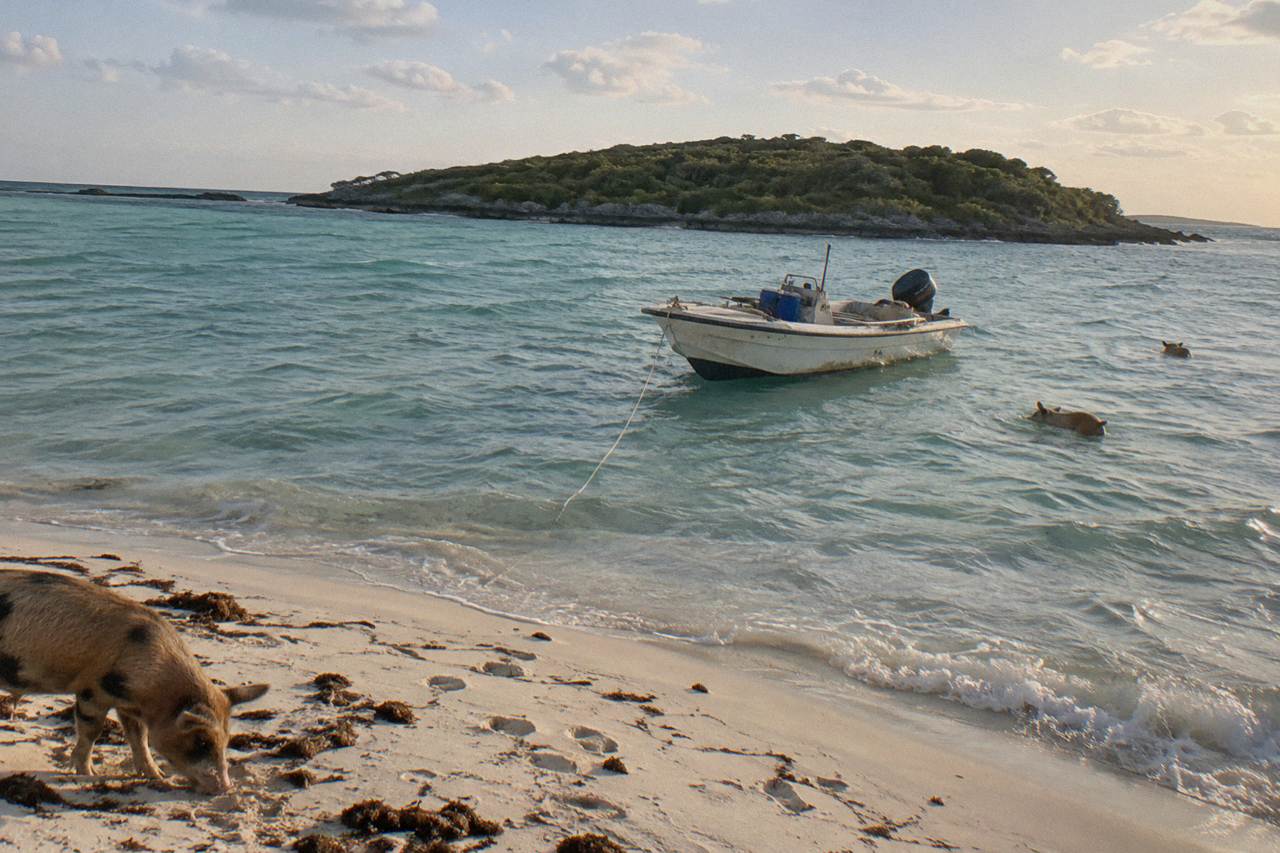 Clear turquoise water around a small Bahamian island with a tour boat anchored offshore