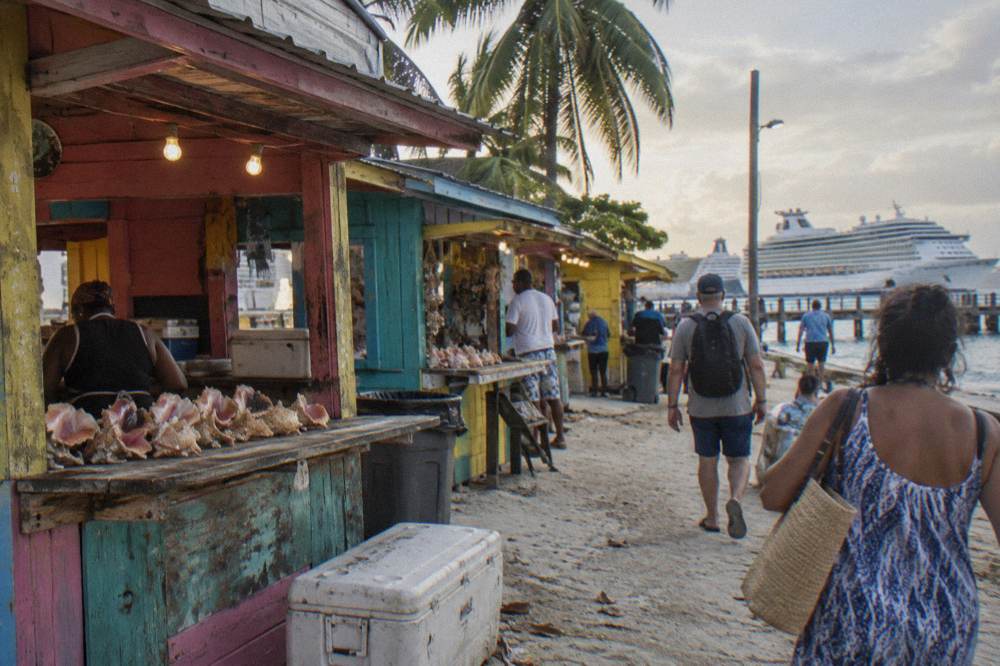 Colorful wooden seafood shack buildings along a waterfront street at golden hour.