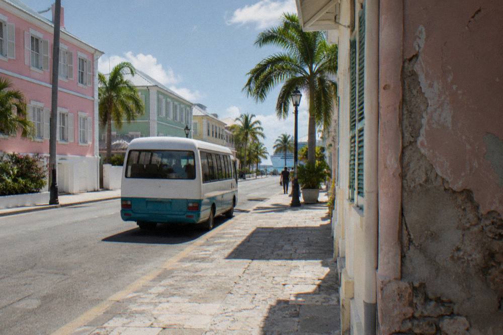 Pastel colonial buildings line a downtown Nassau street in bright sunlight