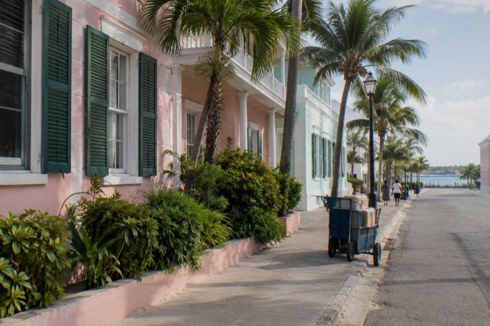 Pastel colonial buildings along a downtown Nassau street with palm trees