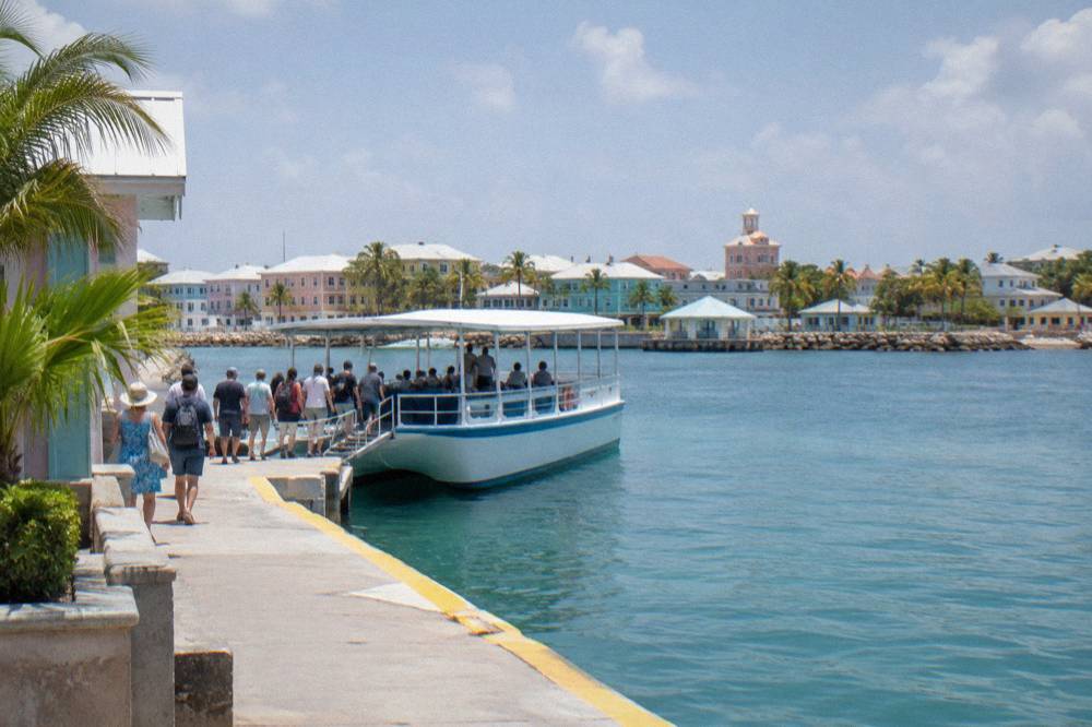 Passengers boarding a small tour boat at a downtown Nassau pier