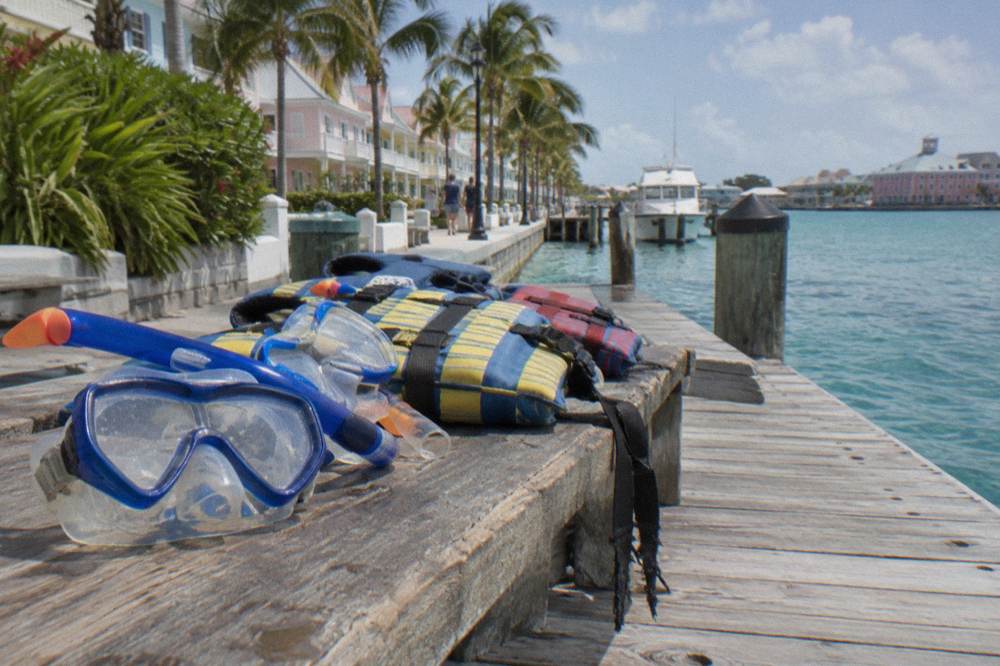 Snorkel masks and life vests arranged on a boat bench