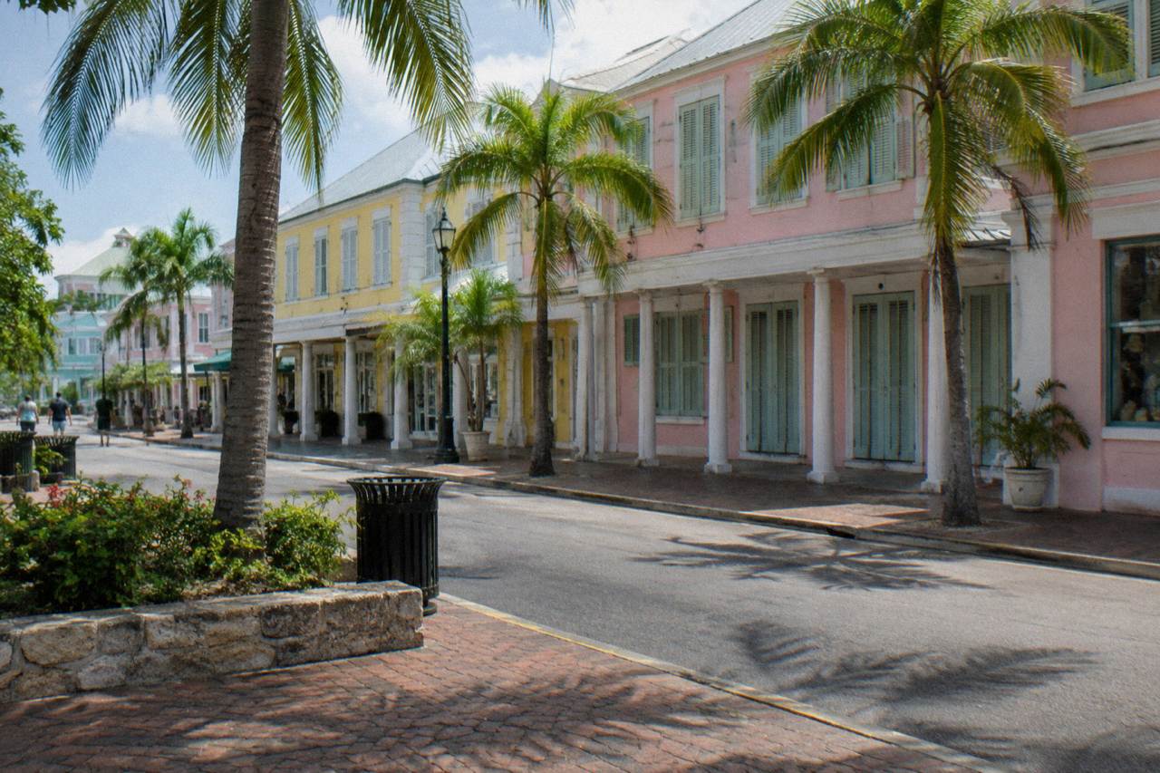 Pastel colonial buildings along a quiet Nassau street with palm trees