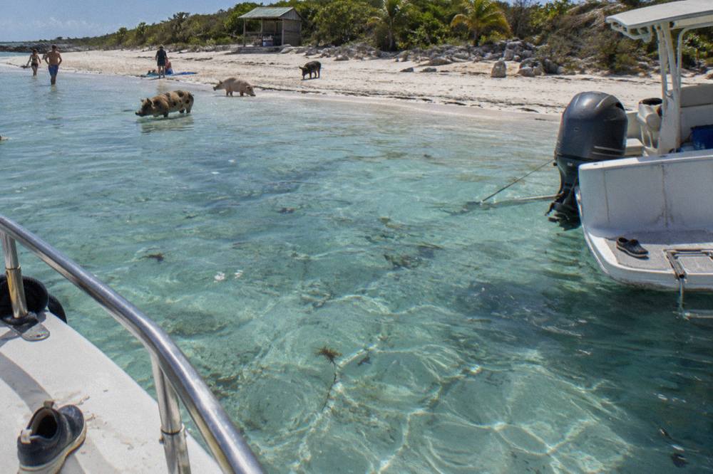 Speedboat anchored beside a small Exuma cay with shallow turquoise water