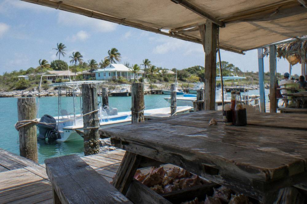 Shaded lunch table on a dock beside boats in a small cay marina
