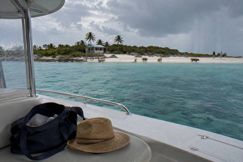 A nearly empty day bag on a boat deck with a towel and hat, ready for a beach return trip
