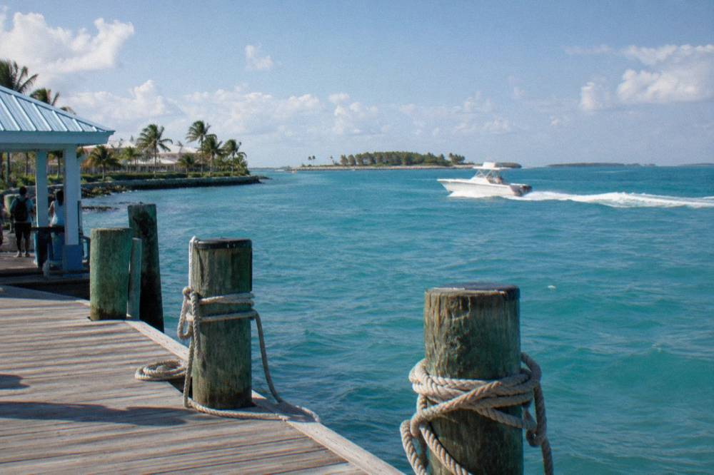 A powerboat crossing open turquoise water toward distant low islands