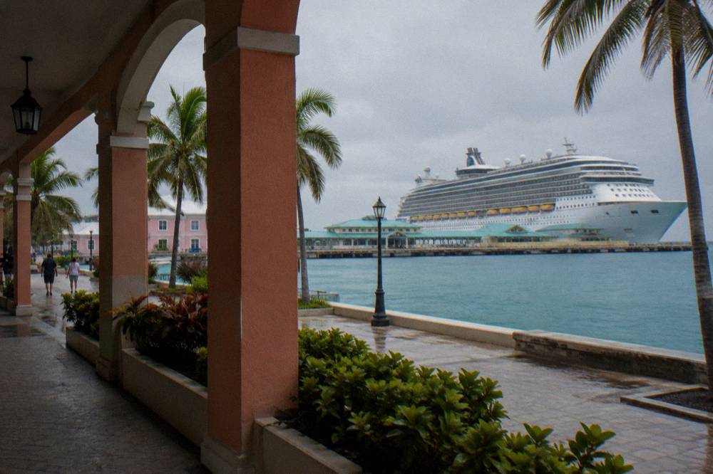 A cruise ship docked at a waterfront port terminal in Nassau